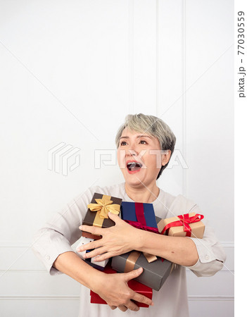 Senior asian woman holding mount of gift boxes, enjoying many best presents. 77030559
