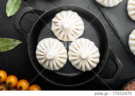 Manti, Turkish traditional ravioli, in frying cast iron pan, on black stone background, top view flat lay Manti, Turkish traditional ravioli, in frying cast iron pan, on black stone background, top view flat lay 77032070