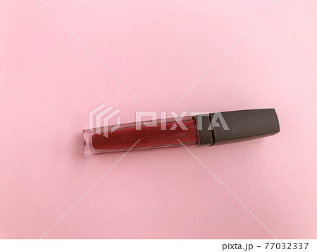 Lipstick and applicator wand on pastel pink backgrpund. Liquid lip stick open tube. Makeup cosmetic product. Top view, flat lay, copy space 77032337