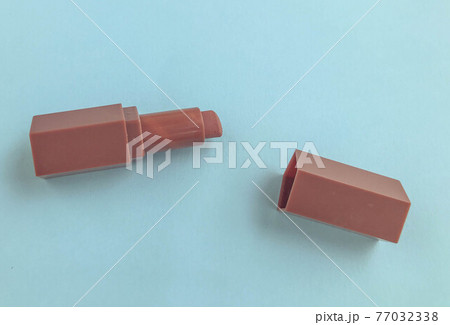 Beautiful fashionable beauty cosmetic glamorous red lipstick for applying makeup on the lips on a blue gentle background 77032338