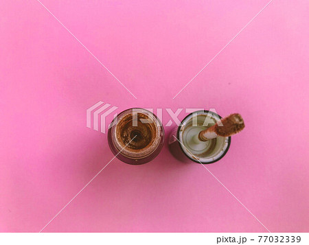 Lipstick and applicator wand on pastel pink backgrpund. Liquid lip stick open tube. Makeup cosmetic product. Top view, flat lay, copy space 77032339