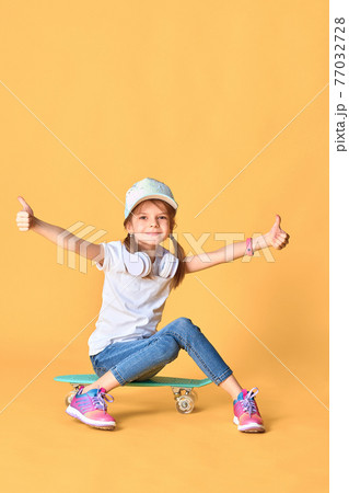 Stylish funny girl wearing white t-shirt, blue jeans and sneaker Stylish funny girl wearing white t-shirt, blue jeans and sneaker 77032728