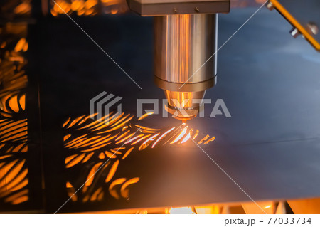 Laser cutting machine working with sheet metal with sparks in dark Laser cutting machine working with sheet metal with sparks in dark 77033734