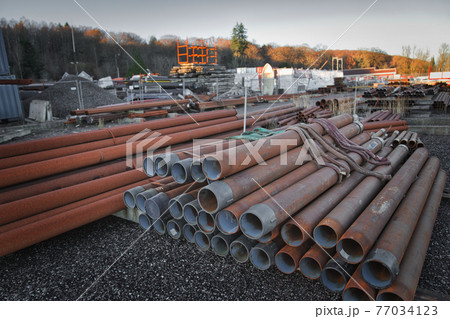 屋外に置かれた工事用の資材 77034123