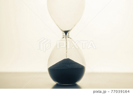 Hourglass on a light background. Time is money. Business solutions in time. Hourglass on a light background. Time is money. Business solutions in time. 77039164