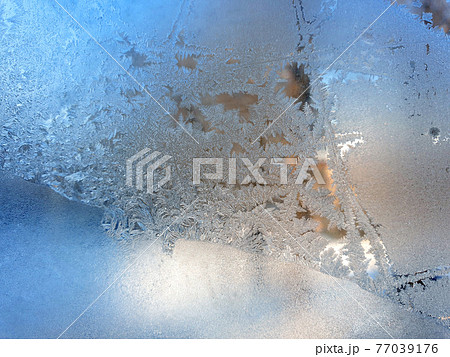 frosty patterns on the window glass closeup. natural textures and backgrounds 77039176