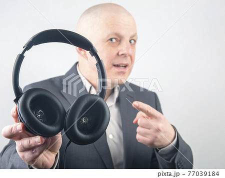 business man advertises headphones for listening to music. 77039184