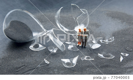 miniature people. elderly people walk near the broken hourglass. loss of life time miniature people. elderly people walk near the broken hourglass. loss of life time 77040003