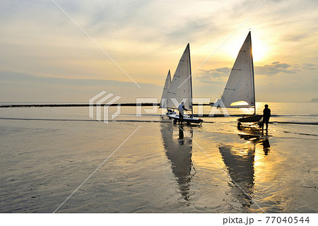 夕陽の染まる材木座海岸に停泊するヨット 77040544