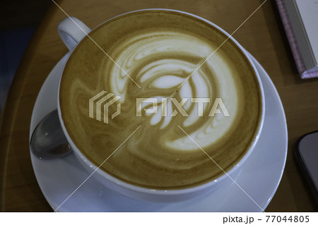 A cup of latte on the table A cup of latte on the table 77044805