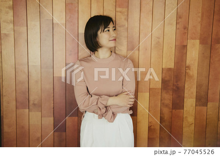 Woman standing by wooden wall 77045526