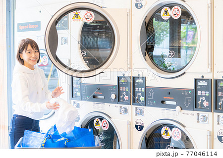 コインランドリーで洗濯する女性 77046114