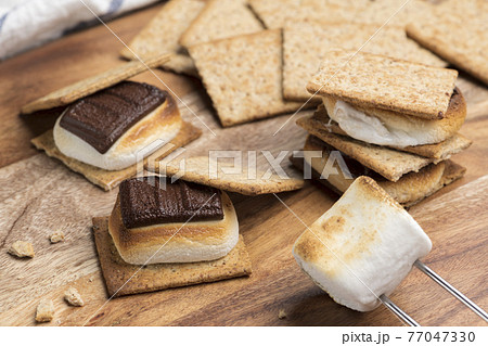 焼いたマシュマロとチョコレートをクラッカーに挟んだスモア 焼いたマシュマロとチョコレートをクラッカーに挟んだスモア 77047330