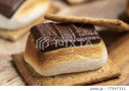 焼いたマシュマロとチョコレートをクラッカーに挟んだスモア 焼いたマシュマロとチョコレートをクラッカーに挟んだスモア 77047331