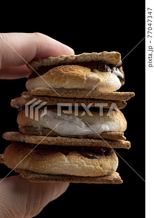 スモアを手で持って食べる　黒バック 77047347