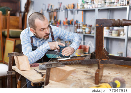 Craftsman repairing antique furniture Craftsman repairing antique furniture 77047913