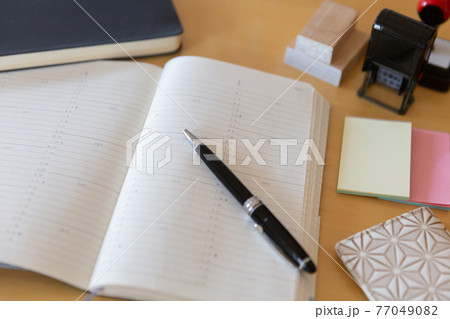 スケジュールのページを開いた手帳 スケジュールのページを開いた手帳 77049082