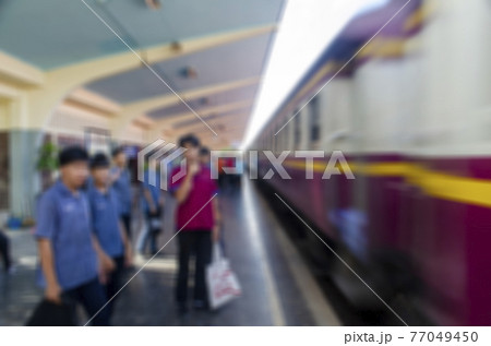 The image is blurred, the passengers are waiting to board the train at the station. The image is blurred, the passengers are waiting to board the train at the station. 77049450