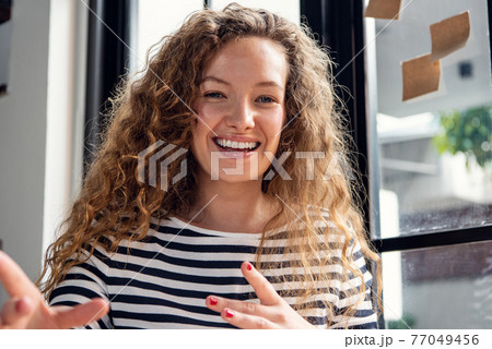 Close up shot of happy smiling Caucasian woman talking while making video call conference at home 77049456