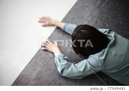 白と黒の床で這いつくばる女性社員の写真素材