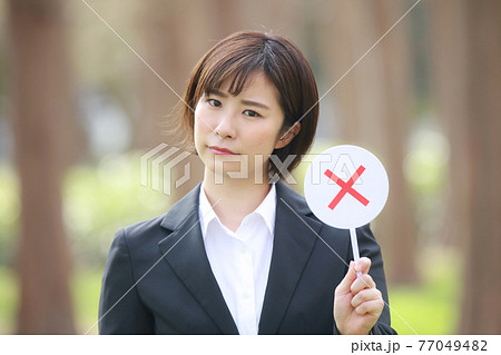 ×札を持つ女性社員 77049482