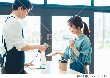 スマホのバーコードを読み取る男性店員 77050315