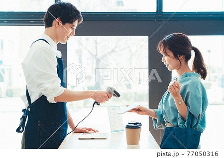 スマホのバーコードを読み取る男性店員 77050316