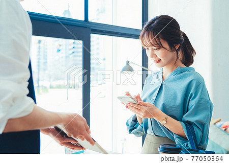 レジでの会計でスマホ決済の準備をする女性 77050364