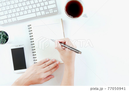 Businessman working in modern white office desk table with keyboard computer, notebook, tree, glasses and cup of coffee. Top view with copy space, 77050941
