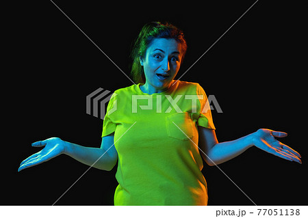Portrait of beautiful woman isolated on dark background in neon light. 77051138