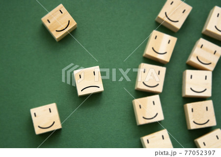 Depression, mental health abstract concept. Sad and happy smiles on wooden blocks over green background. 77052397