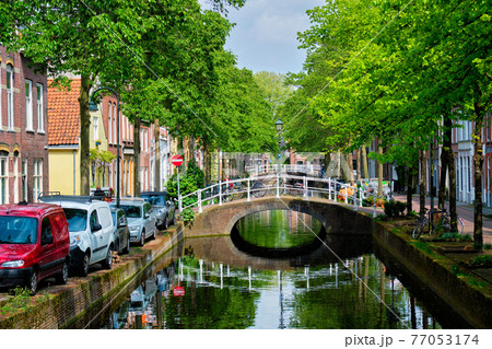 Cars on canal embankment in street of Delft. Delft, Netherlands Cars on canal embankment in street of Delft. Delft, Netherlands 77053174