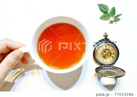 白背景の紅茶と懐中時計 バラの葉2 冷たい光下 白背景の紅茶と懐中時計 バラの葉2 冷たい光下 77053386