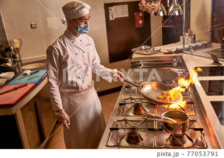Burning vegetables on fire lying in frying pan Burning vegetables on fire lying in frying pan 77053791