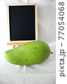 グリーンマンゴーと黒板 77054068