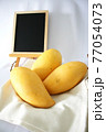 イエローマンゴーと黒板 77054073