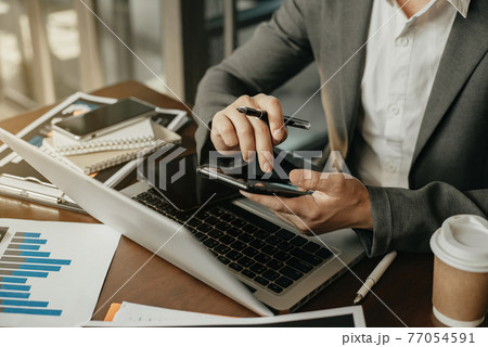 Businesswomen hand using smart phone, tablet payments online shopping, omni channel, digital tablet docking keyboard computer at office in sun light. 77054591