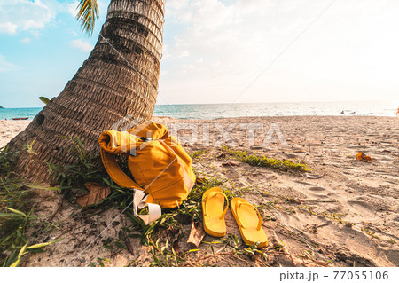 Sea vacation - Yellow Bags and Flip flops on the beach in the evening Sea vacation - Yellow Bags and Flip flops on the beach in the evening 77055106