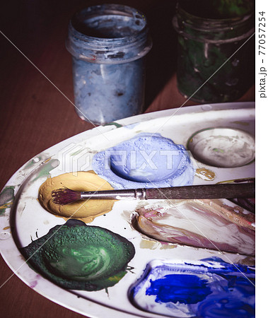 Palette with paints and a brush 77057254