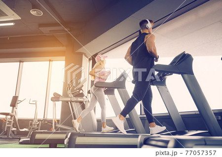 Music and exercises go together. Couple working exercise on trea 77057357