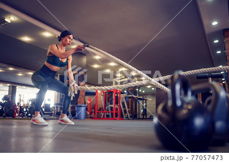 Caucasian fit woman dressed in sportsoutfit posing with battle r Caucasian fit woman dressed in sportsoutfit posing with battle r 77057473
