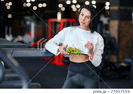 sport woman eating salad 77057559