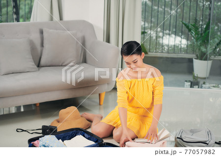 woman packing suitcases at home 77057982