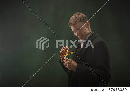 Young man in art action isolated on dark green background. Retro style, comparison of eras concept. 77058089