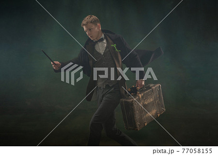 Young man in art action isolated on dark green background. Retro style, comparison of eras concept. 77058155