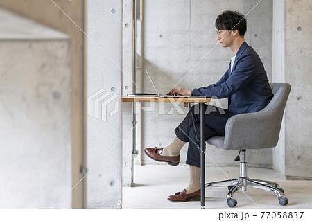 ノートパソコンで作業をする30代の男性　カジュアルビジネス　イメージ 77058837