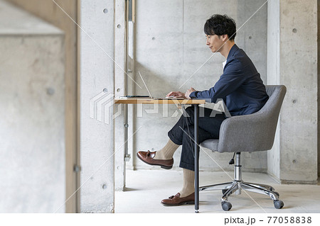 ノートパソコンで作業をする30代の男性　カジュアルビジネス　イメージ 77058838
