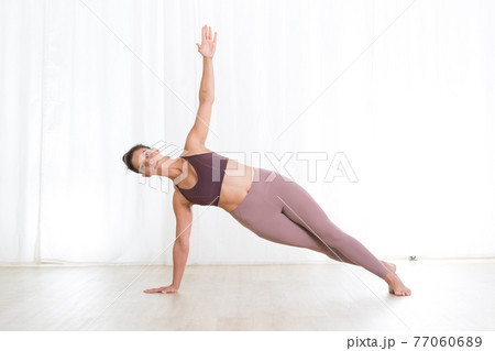 Portrait of active sporty young woman practicing yoga in studio. Healthy active lifestyle, working out indoors in gym Portrait of active sporty young woman practicing yoga in studio. Healthy active lifestyle, working out indoors in gym 77060689