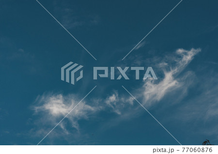 Dark blue sky with small cloud air, cloud evaporates under influence sun Dark blue sky with small cloud air, cloud evaporates under influence sun 77060876