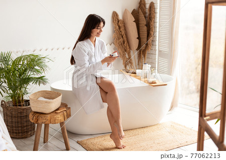 Attractive Woman Applying Moisturizer Cream Caring For Skin In Bathroom Attractive Woman Applying Moisturizer Cream Caring For Skin In Bathroom 77062213
